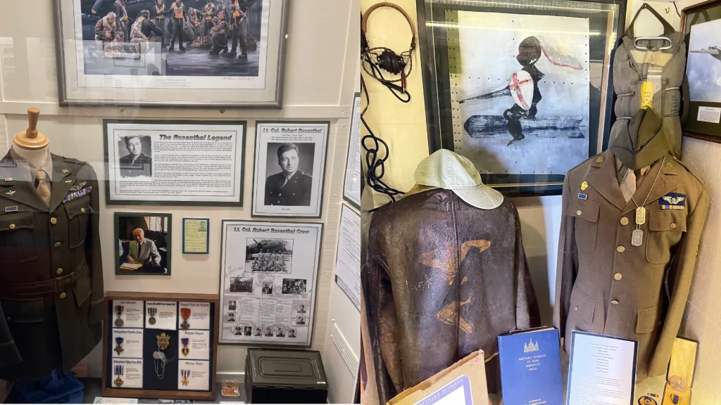 A museum display featuring military memorabilia, including uniforms, framed photographs, paintings, and informational plaques about historical figures and events.