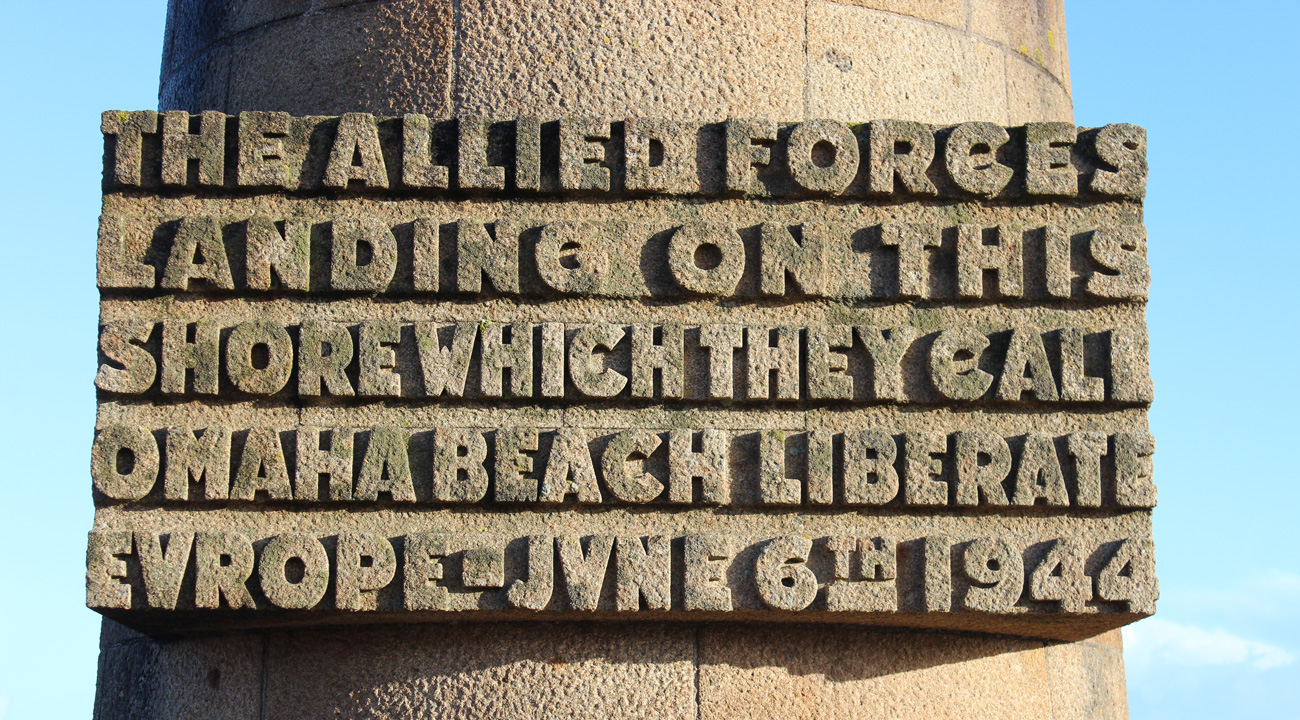 Stone plaque inscription commemorating allied forces landing at omaha beach on june 6, 1944, to liberate europe during wwii.