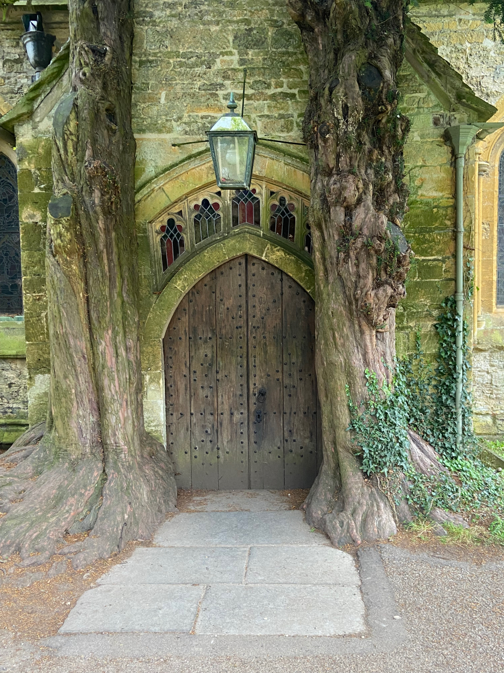 Wooden church door with trees each side